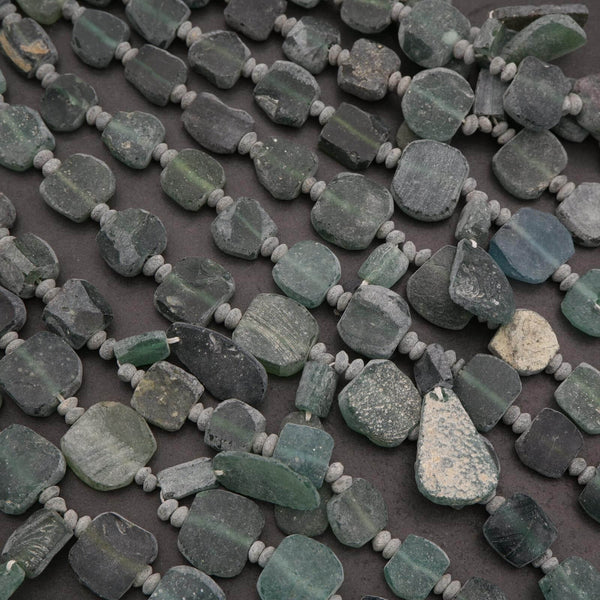 String of green stone beads on a dark surface