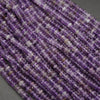 Close-up of a string of purple beads on a gray background