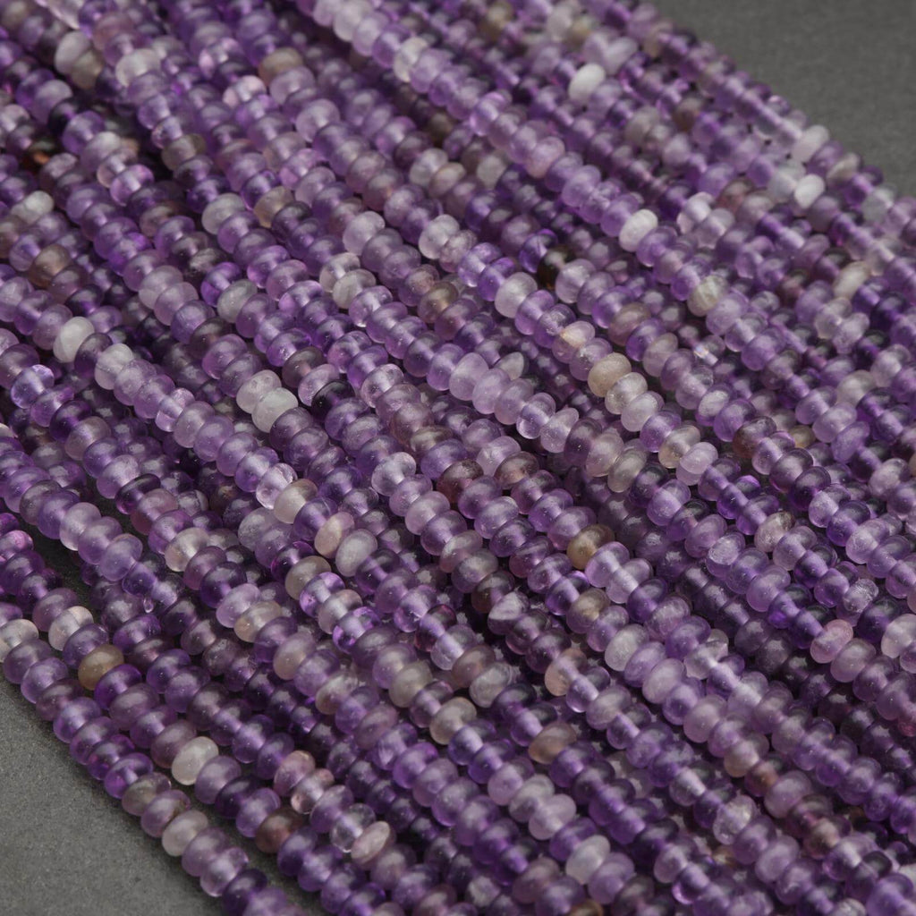 Close-up of a string of purple beads on a gray background