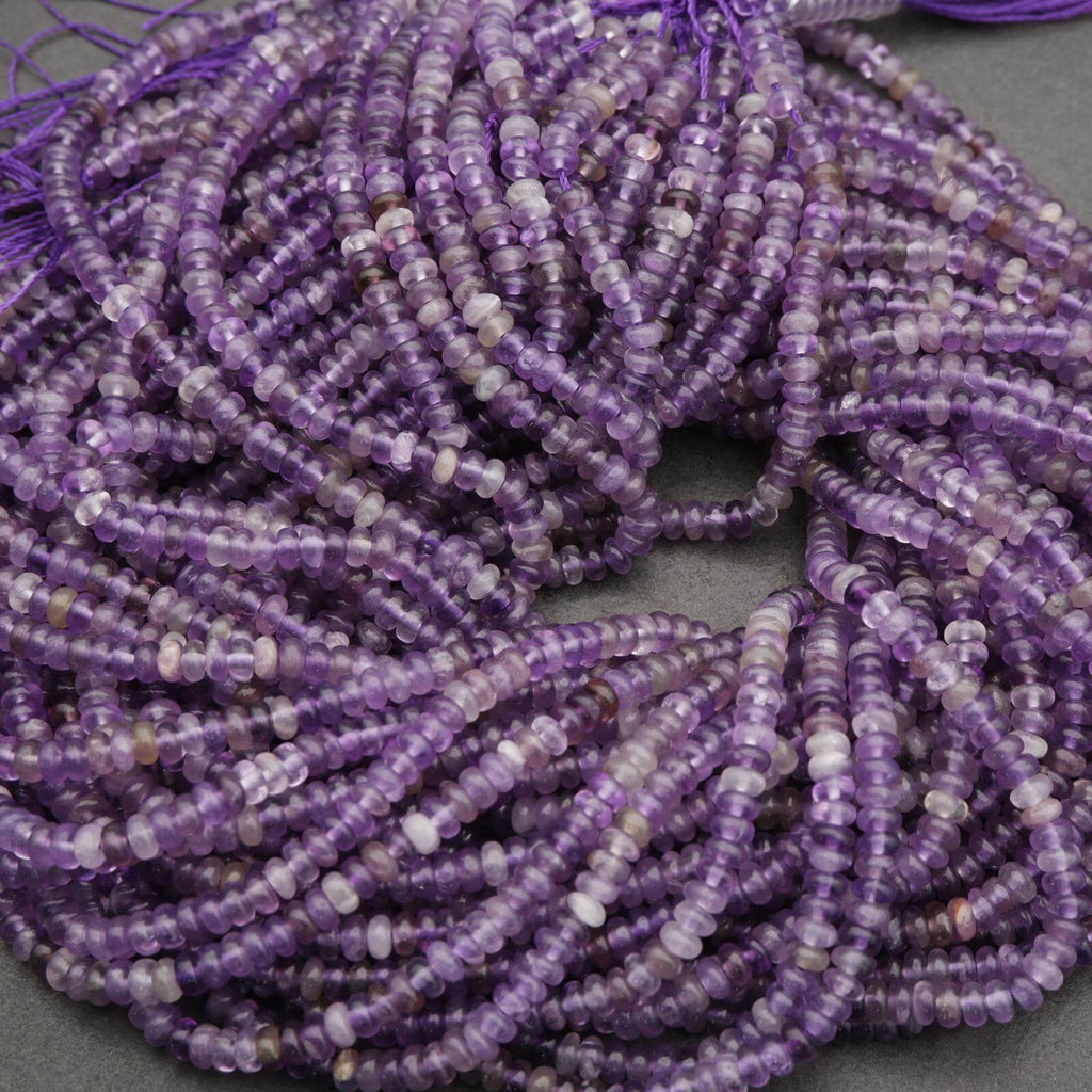 Close-up of a string of purple beads on a gray surface