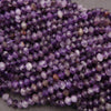 Close-up of purple faceted beads on a gray background