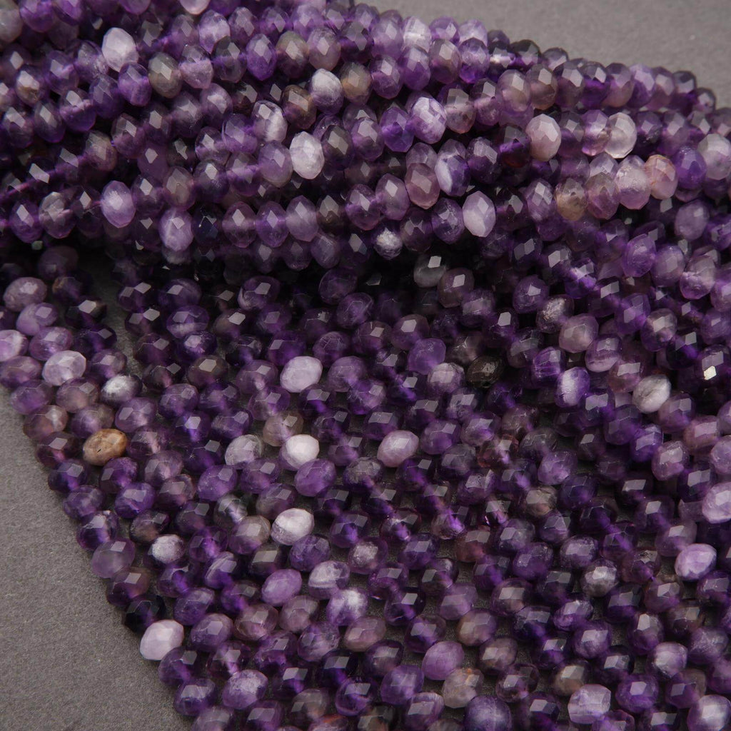 Close-up of a strand of purple beads on a gray surface