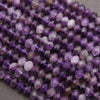 Close-up of purple faceted beads on a gray background