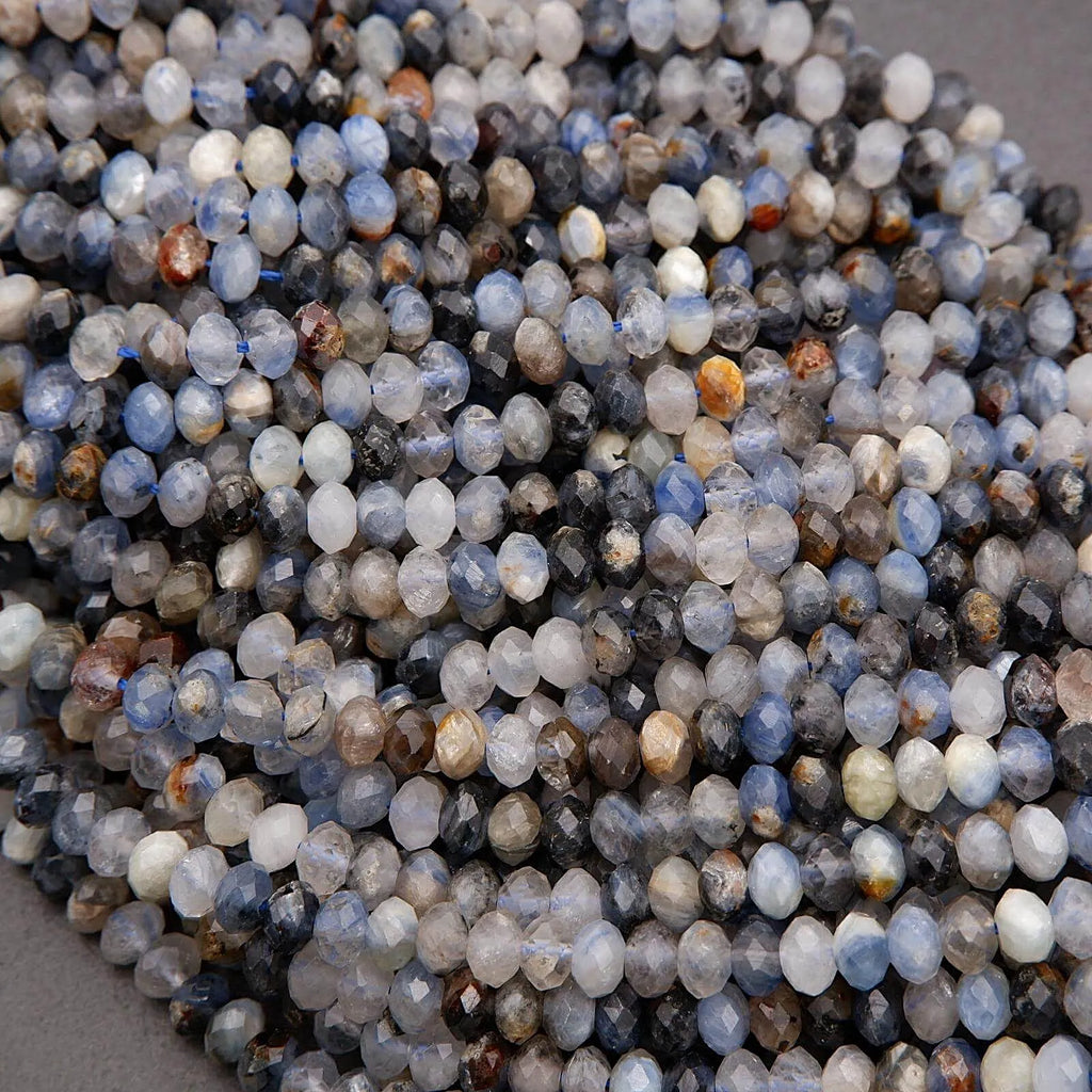 Close-up of faceted gemstones in various colors on a neutral background