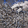 String of blue and gray beads with barcodes and labels on a gray surface