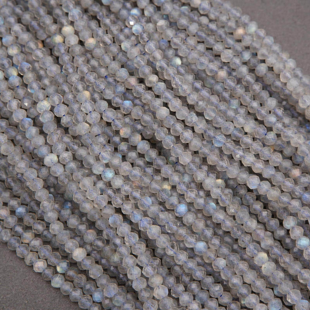 Multiple strands of micro-faceted labradorite beads with gray base color and soft blue iridescent highlights.