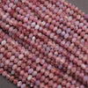 Close-up of pink and purple marbled beads on a gray surface