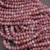 Close-up of pink and purple beads on a gray background