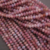 Close-up of pink and purple beads on a gray background