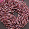 String of pink beads on a dark surface