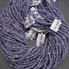 Purple beads with price tags on a gray background