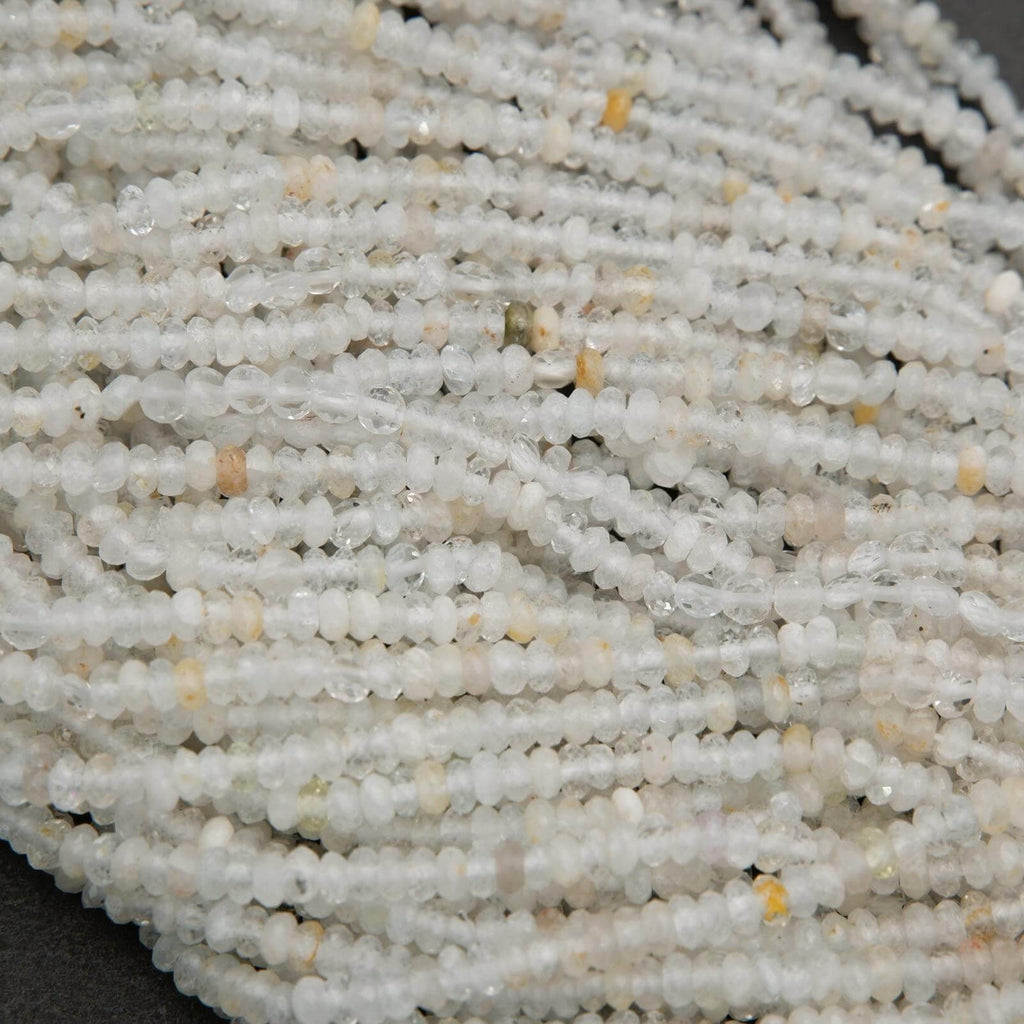 Clear faceted rondelle shape beads with yellowish inclusions.