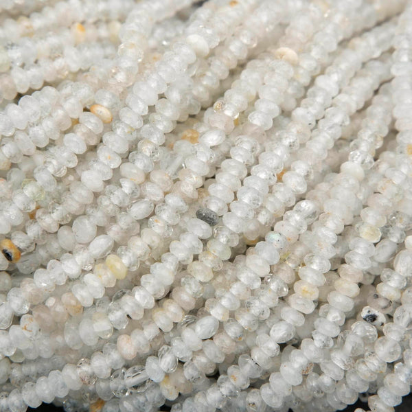 Clear faceted rondelle shape beads with yellowish inclusions.