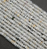 Clear faceted rondelle shape beads with yellowish inclusions.