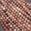 Close-up of pink and brown marbled beads on a gray surface