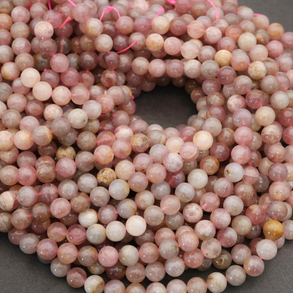 Close-up of a string of pink and white marbled beads on a dark background