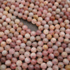 Close-up of pink and brown marbled beads on a dark background