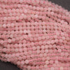 Close-up of pink beads on a string with a dark background