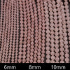 Close-up of pink beads with size labels 6mm, 8mm, and 10mm on a dark background.