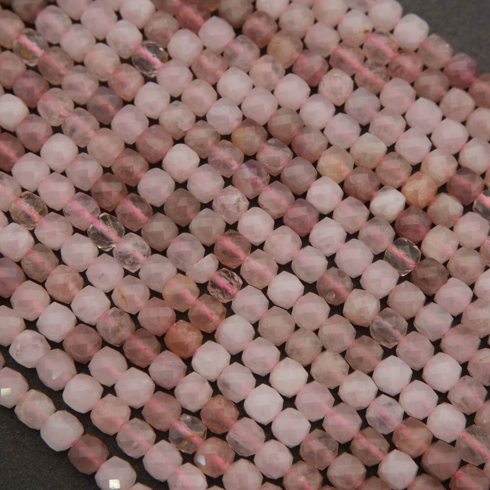 Close-up of pink and white beads on a dark surface