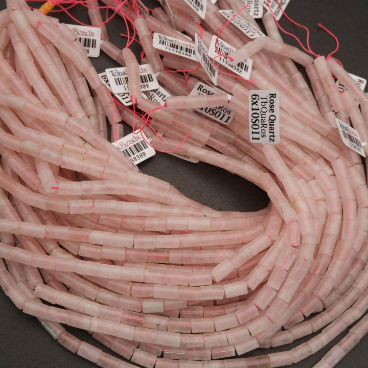 Pink cylindrical beads with labels on a dark surface