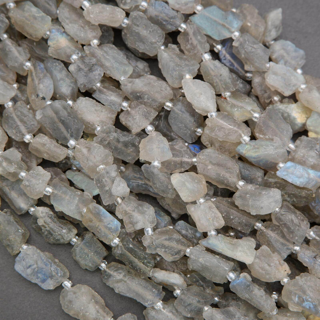 Close-up of raw labradorite beads on a gray background