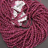 Close-up of pink beads with price tags on a gray background