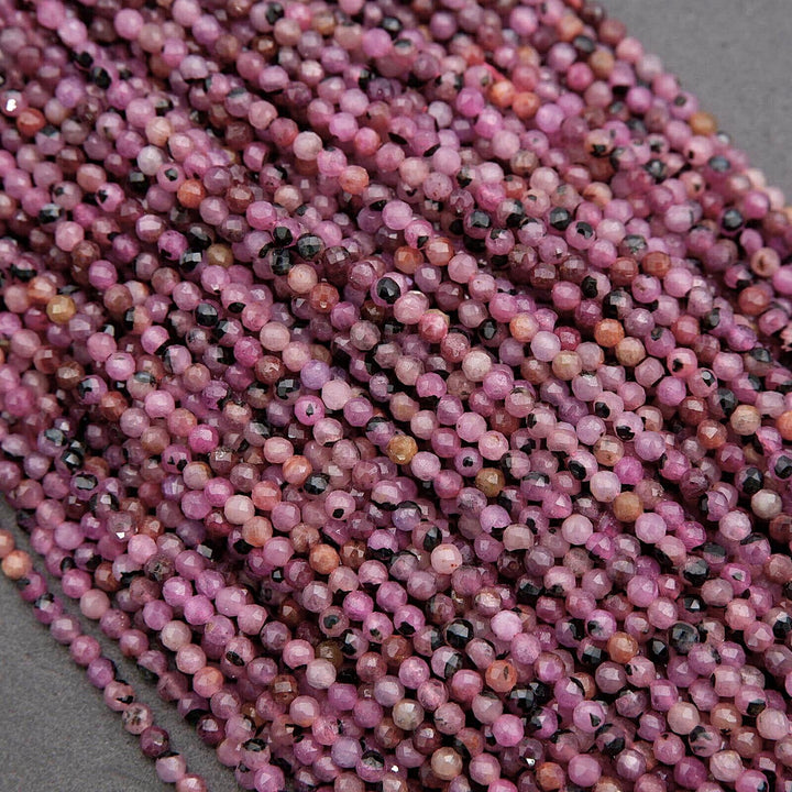 Close-up of pink and black beads on a gray background