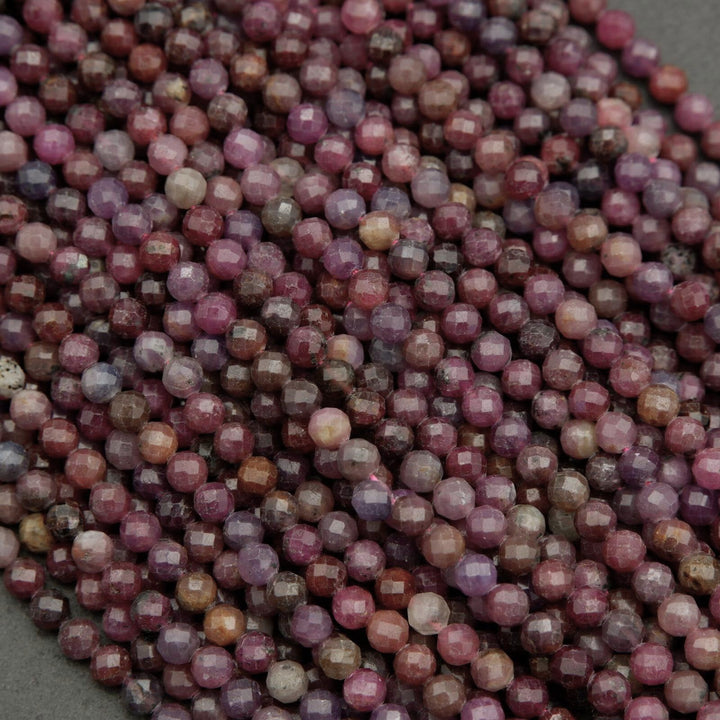 Faceted round beads with hues ranging from burgundy to violet.