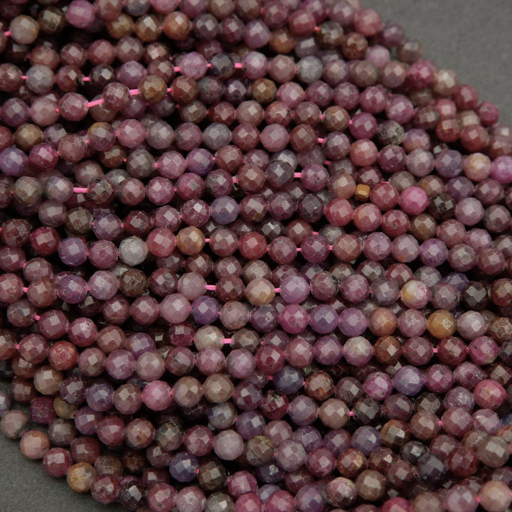Faceted round beads with hues ranging from burgundy to violet.
