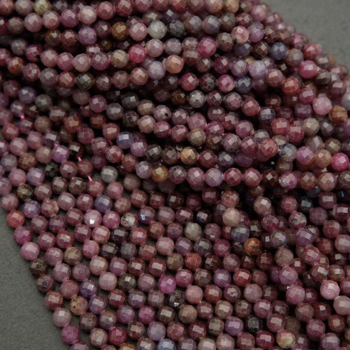 Faceted round beads with hues ranging from burgundy to violet.