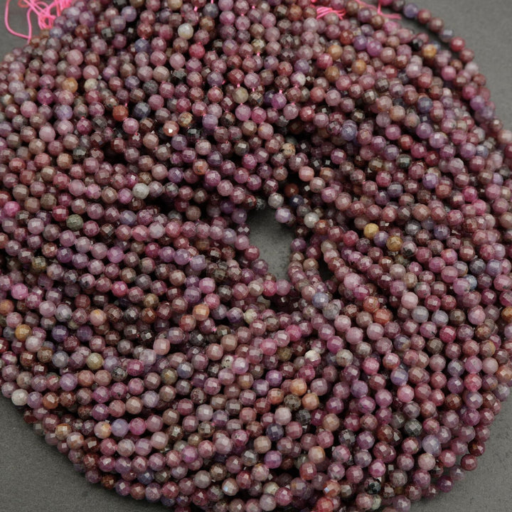 Faceted round beads with hues ranging from burgundy to violet.