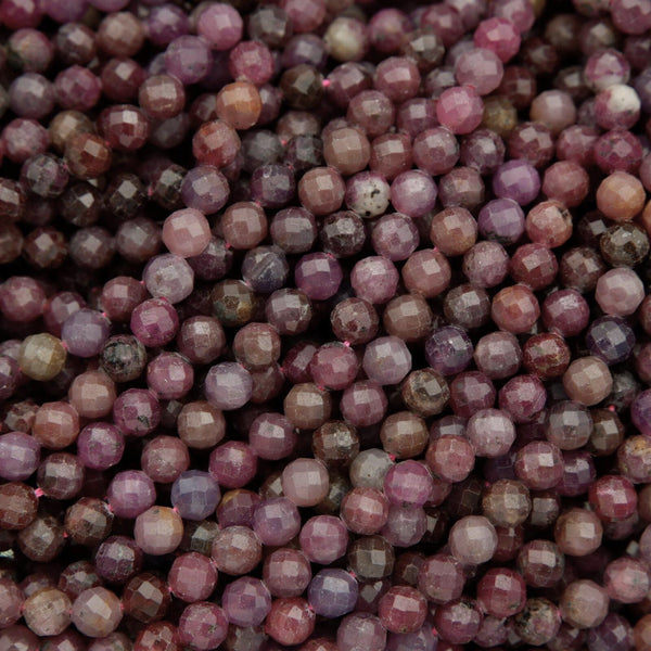 Faceted round beads with hues ranging from burgundy to violet.