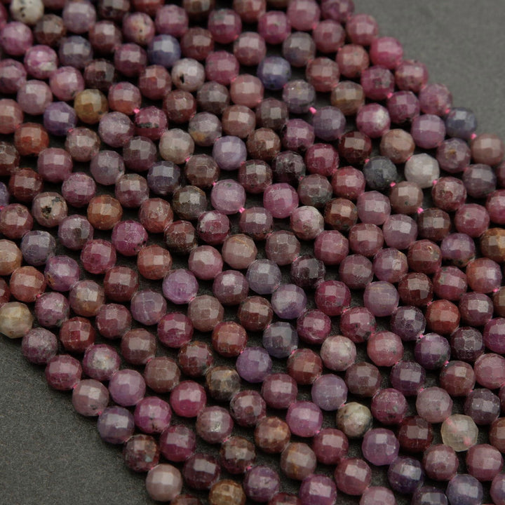 Faceted round beads with hues ranging from burgundy to violet.