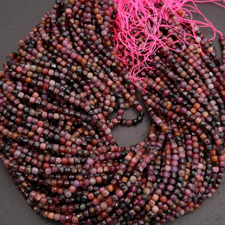 Multiple strands of faceted ruby beads arranged together.