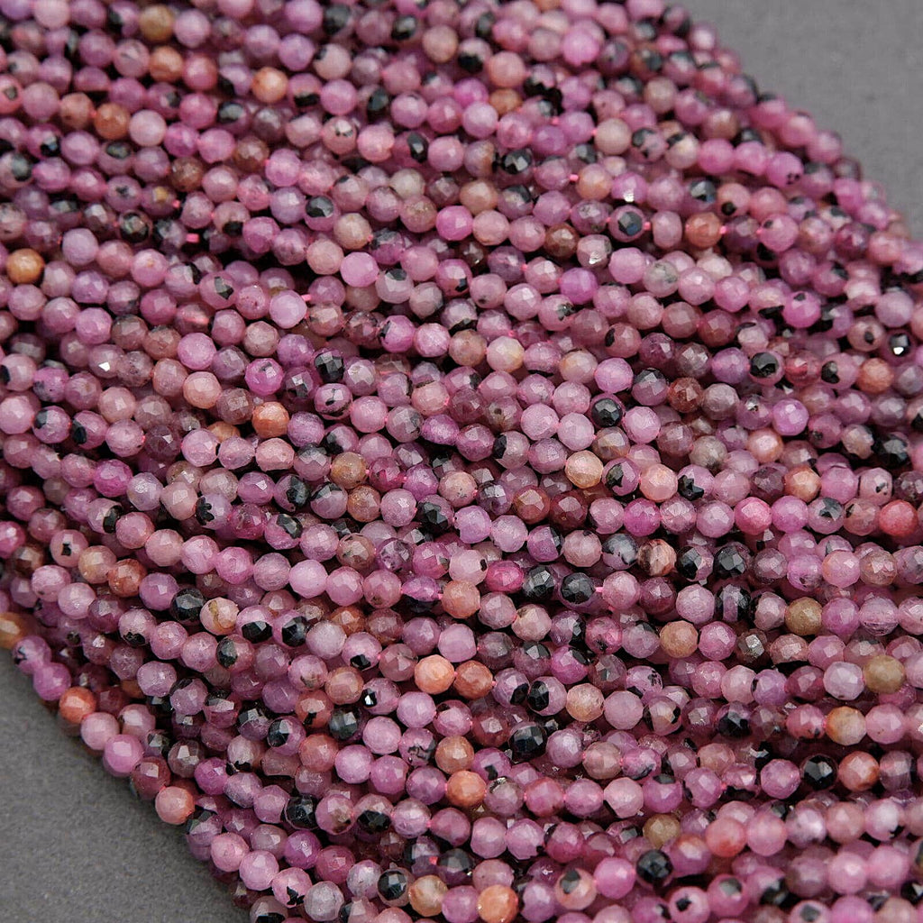 Close-up of pink and black beads on a gray background