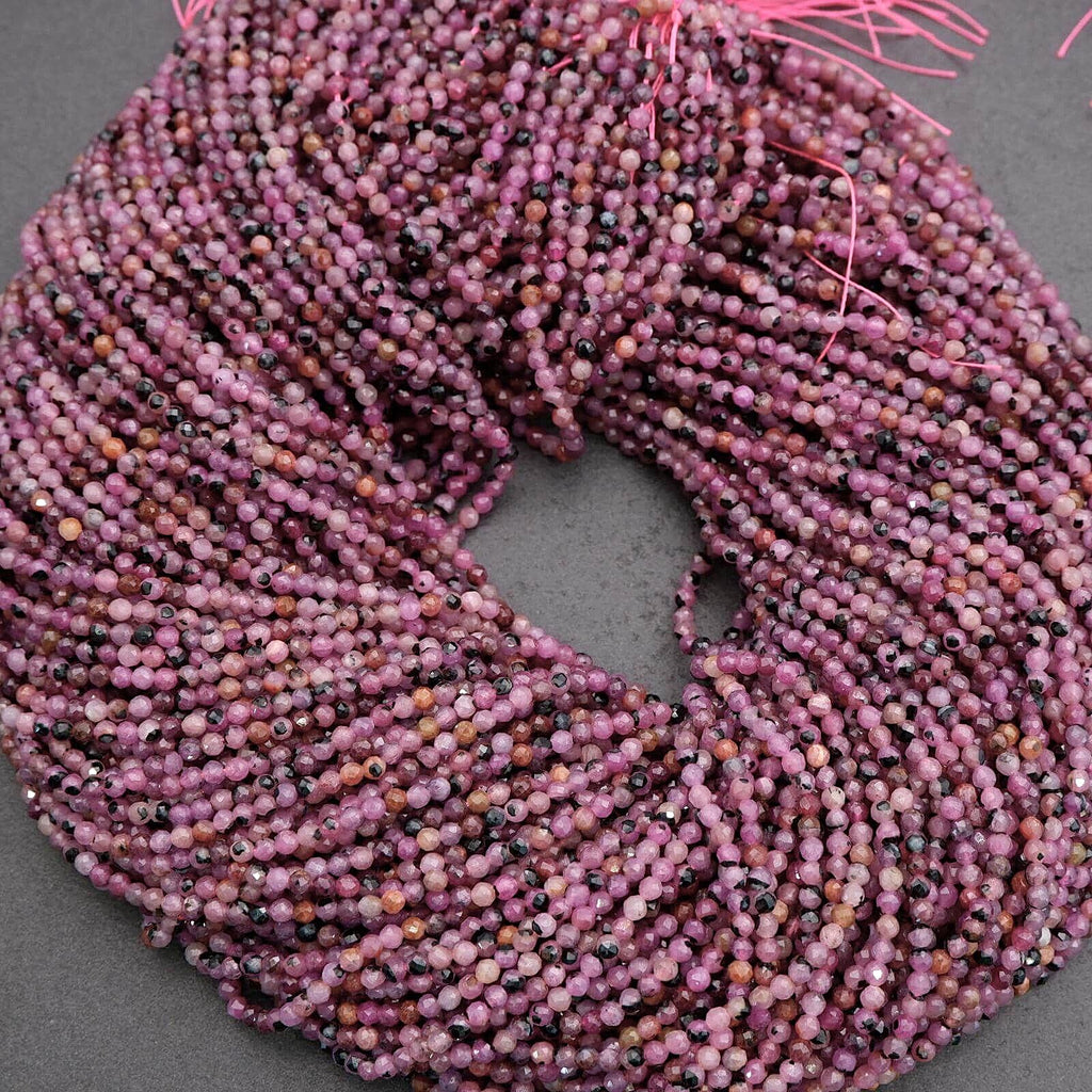 Close-up of a skein of pink yarn with black specks on a gray background