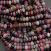 Strands of genuine ruby and sapphire beads featuring pink, blue, purple, and brown tones