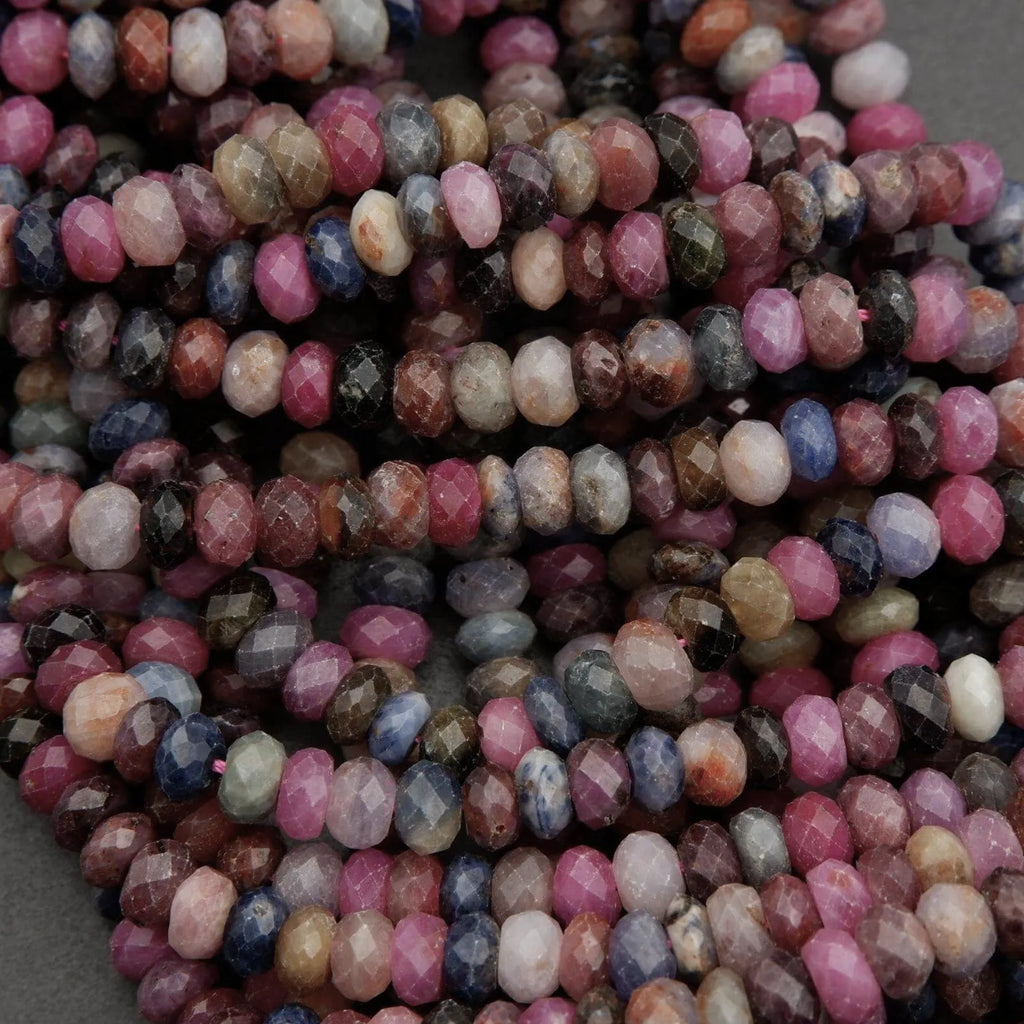 Strands of genuine ruby and sapphire beads featuring pink, blue, purple, and brown tones