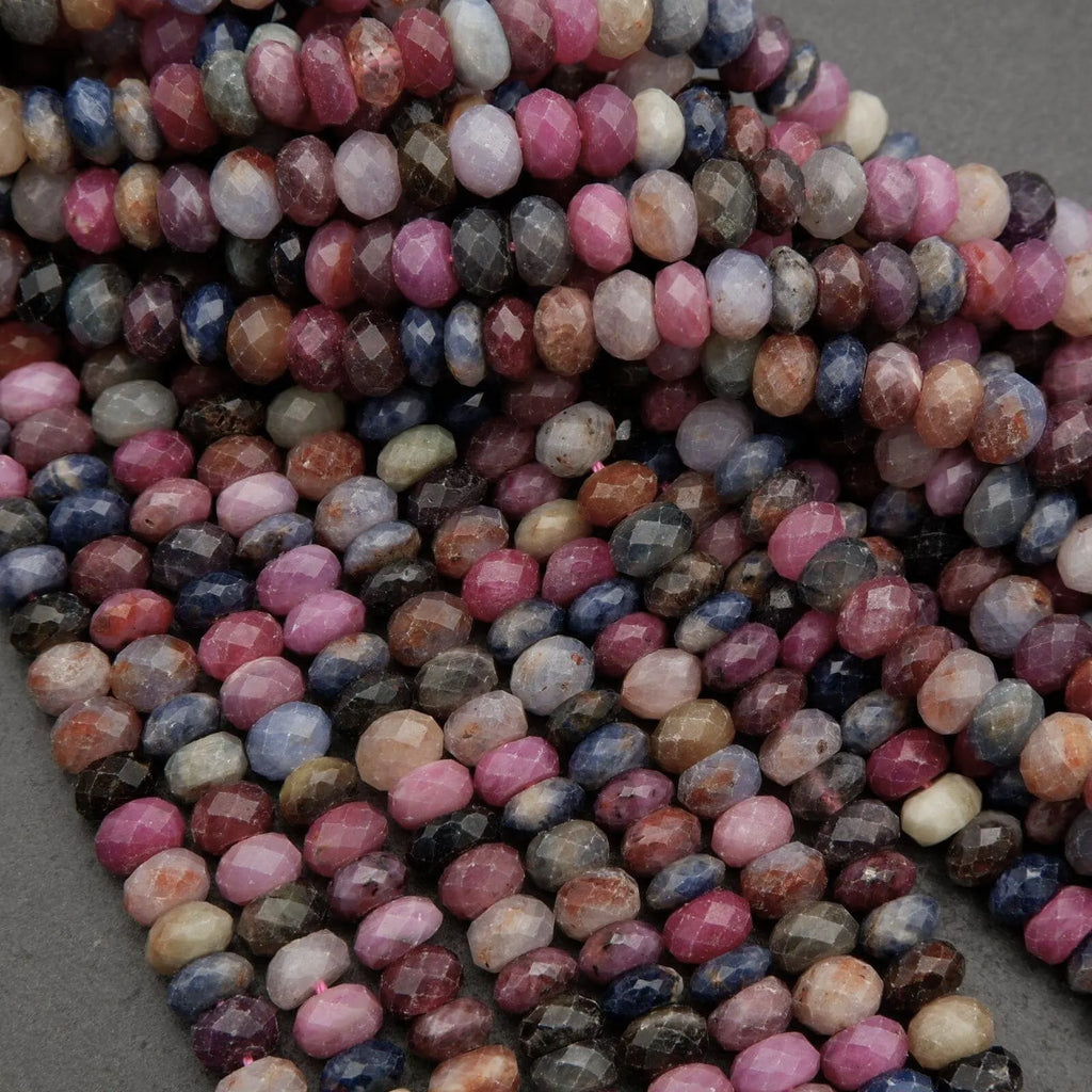 Strands of genuine ruby and sapphire beads featuring pink, blue, purple, and brown tones