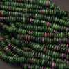 Close-up of green and pink beads on a dark background