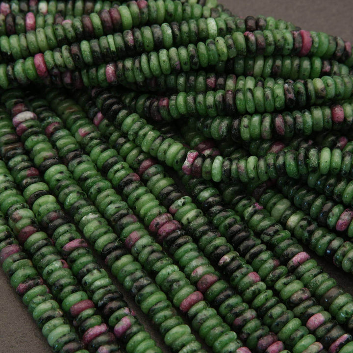 Close-up of green and pink beads on a gray surface