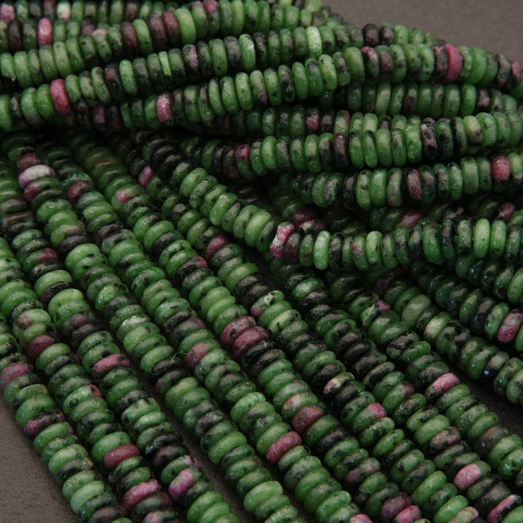 Close-up of green and pink beads on a gray surface
