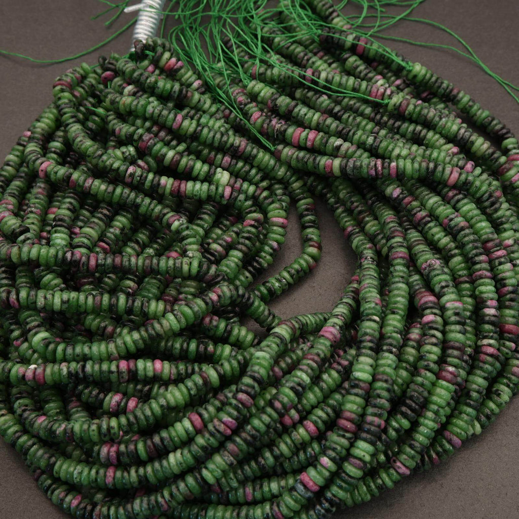 Green and pink beaded necklace on a gray surface