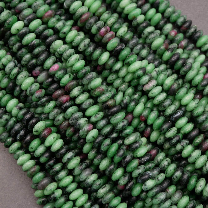 Multiple strands of ruby zoisite rondelle beads layered together, highlighting consistent shape, smooth polish, and natural color variation.