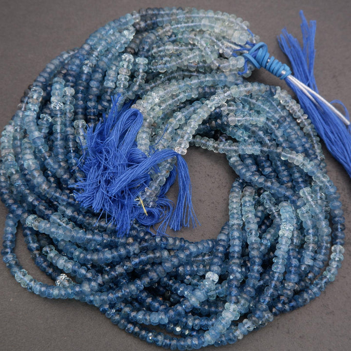 Blue beaded necklace with tassels on a gray background