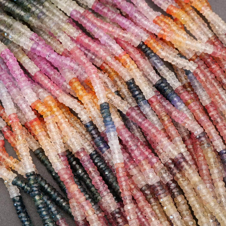 Close-up of multicolored gemstone beads on a gray background