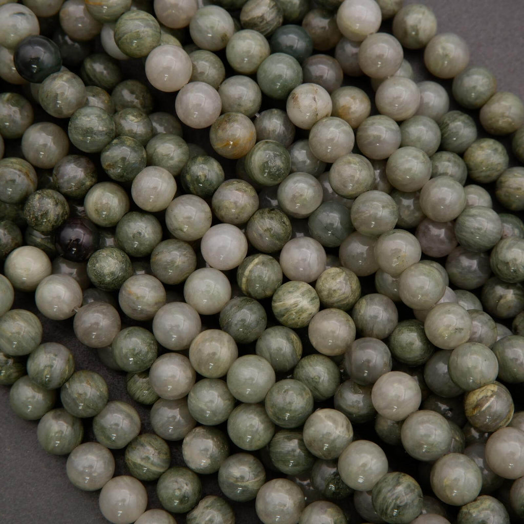 Close-up of green and white marbled beads on a dark background