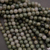 Close-up of green and white beads on a dark surface