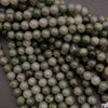 Close-up of green and white beads on a dark surface